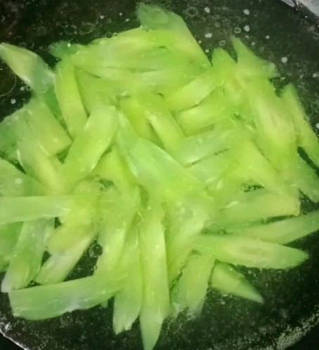莴笋炒猪舌,水开加入少许盐和油,放入莴笋焯水