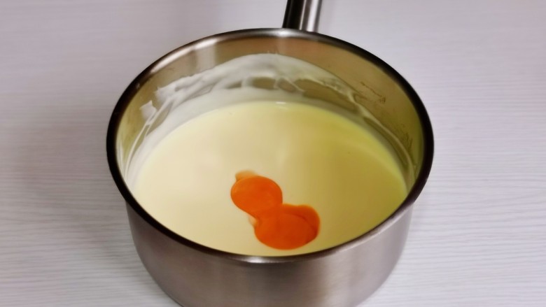 巧克力乳酪蛋糕,将器具从热水中取出,先加入2个蛋黄,搅拌均匀后再加2个搅拌均匀,再加入最后一个与