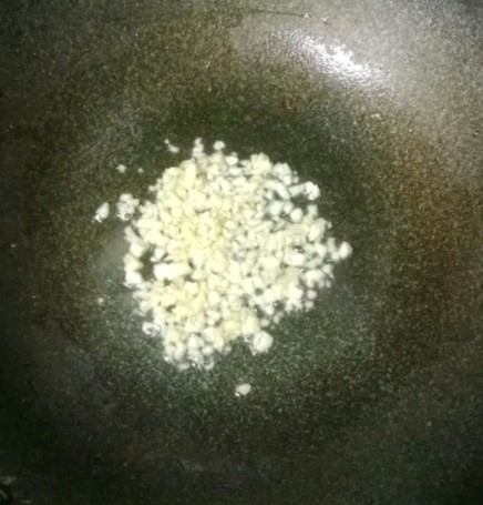 牛肉粒炒豌豆,锅中热油,倒入蒜末炒香