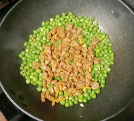 牛肉粒炒豌豆,倒入炒熟的牛肉粒,翻炒均匀即可