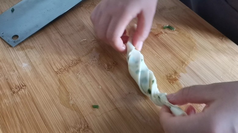 葱油蚕丝饼(饺子皮版),双手反方向拧,再盘成圆形