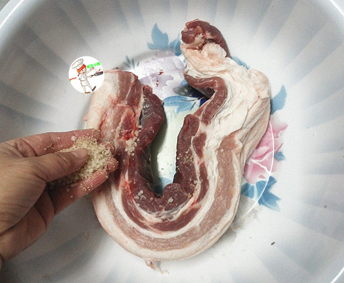 腊肉,五花肉不用洗,直接放入盆中,再将泡菜盐均匀揉搓五花肉的表面,并且确保每一个地方都要抹到