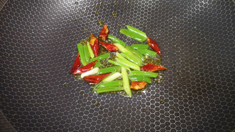炝炒藕片,炒锅内倒适量的<a style='color:red;display:inline-block;' href='/shicai/ 848'>菜籽油</a>烧热,下入小葱和干红辣椒炝香。