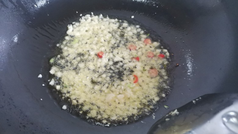 煎酿豆腐,起锅烧油,下入蒜末小米椒,葱白炒香
