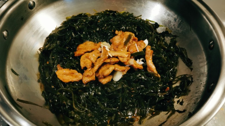 海带炒肉片,放入炒好的肉片,翻炒均匀。