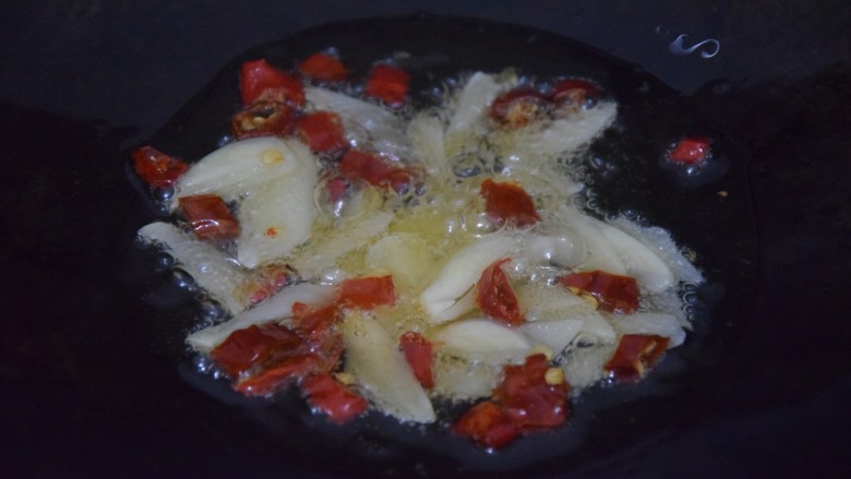 炝炒藕片,热锅凉油,倒入干辣椒跟蒜片爆香