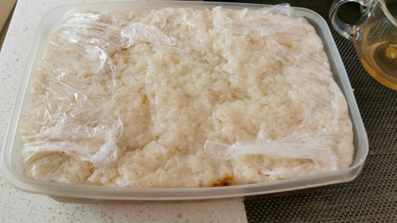 红枣切糕,最后再铺一层糯米饭,覆盖保鲜膜,压上重物静置。
