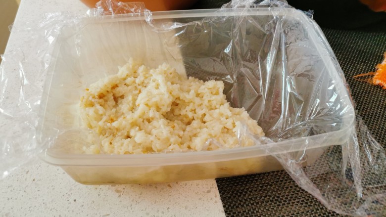 红枣切糕,取一器皿,铺上保鲜膜,平铺一层糯米饭。