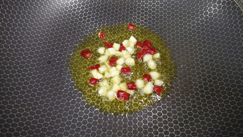 酸豆角炒茭白,炒锅内倒适量的<a style='color:red;display:inline-block;' href='/shicai/ 848'>菜籽油</a>烧热,下入大蒜和干红辣椒炒香。