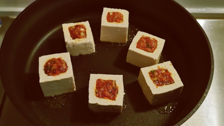 煎酿豆腐,起油锅放入食用油,油热后放入酿好的豆腐煎制。