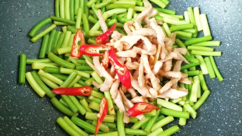 蒜苔五花肉, 下入炒好的肉丝和红辣椒翻炒均匀。