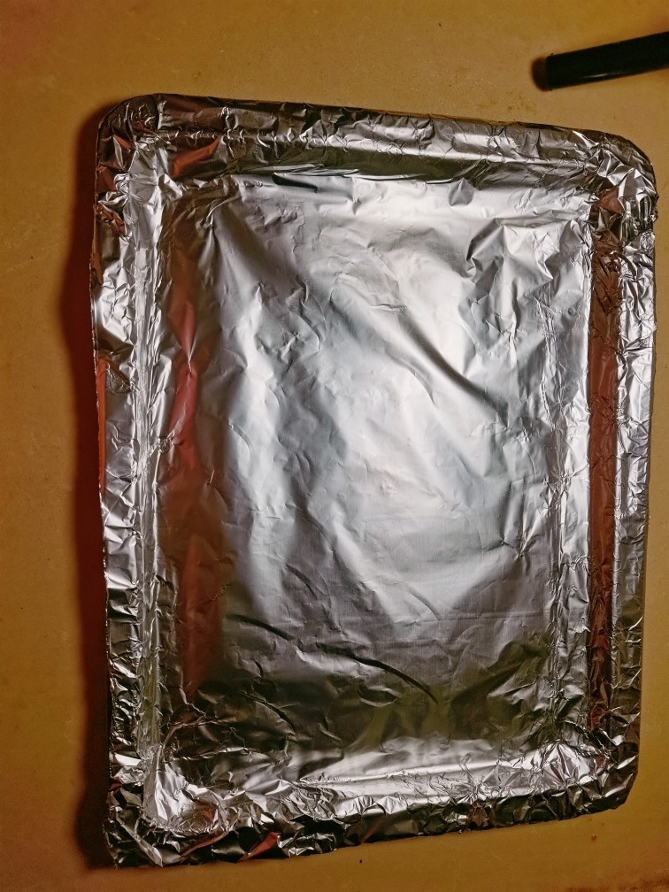 浓情香鸡翼,在烤盘上裹上一张铝箔纸😉,使其将烤盘包裹在内。😜