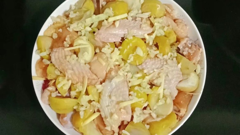 家常鸡块,将板栗和鸡肉铺在蒸盘中,放入蒜末
