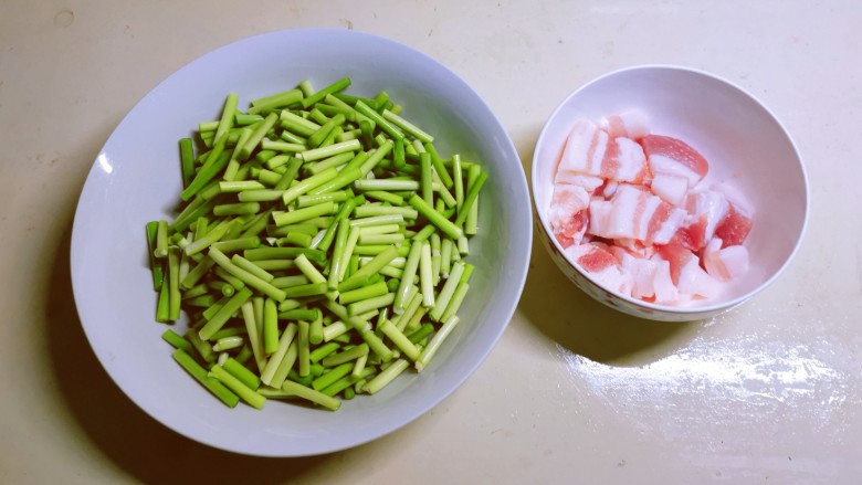 蒜苔五花肉,蒜苔择洗干净切段，五花肉切片。