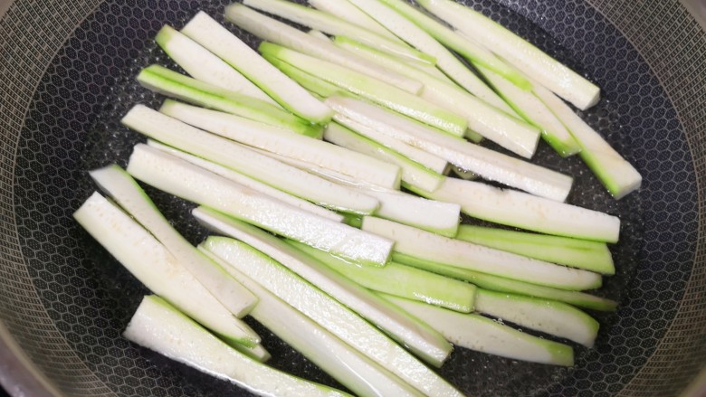 凉拌丝瓜,锅里放水烧开,下入丝瓜条,加入几滴食用油和少许盐,焯水两分钟。