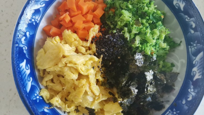 海苔拌饭,把西兰花切碎,加入米饭里,加入胡萝卜丁,鸡蛋碎,海苔碎和黑芝麻