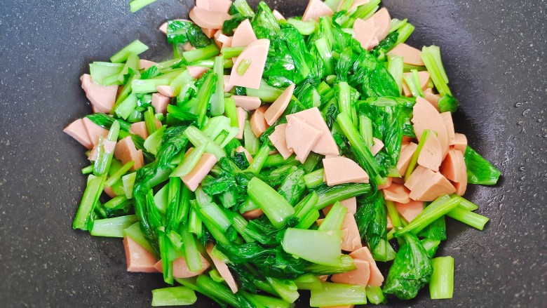 火腿青菜炒鸡蛋,加入火腿肠片,翻炒30秒