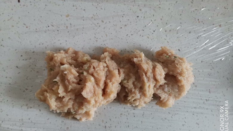 麦乐鸡,正在一个方向搅拌均匀后,放在保鲜膜上