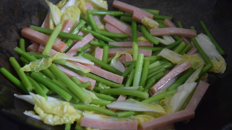 火腿青菜炒鸡蛋,起锅热油,倒入青菜和火腿中火翻炒三分钟左右