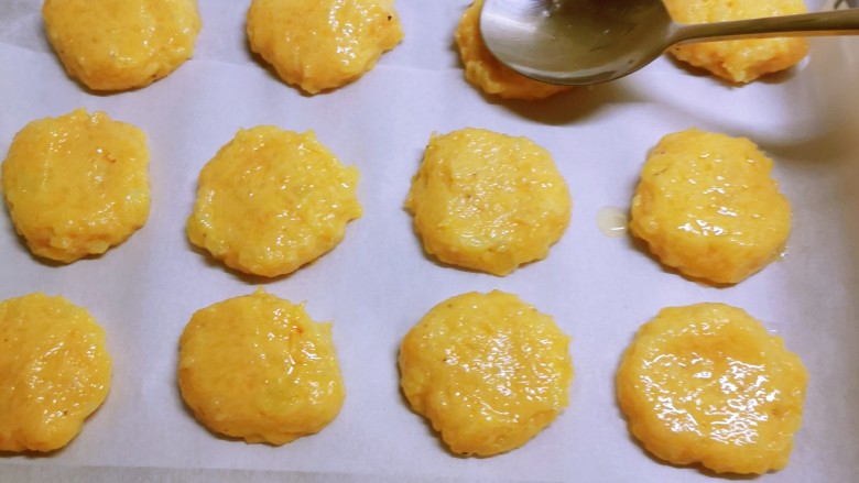 麦乐鸡,取适量肉糜,放到烤盘上,勺子背面抹点油,轻轻压成饼状,依次做好码放整齐。