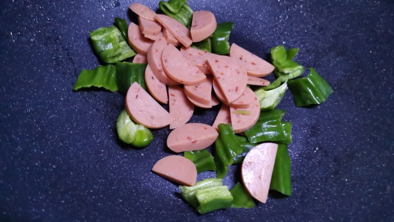火腿青菜炒鸡蛋,锅中喷少许食用油,加入火腿和青椒翻炒