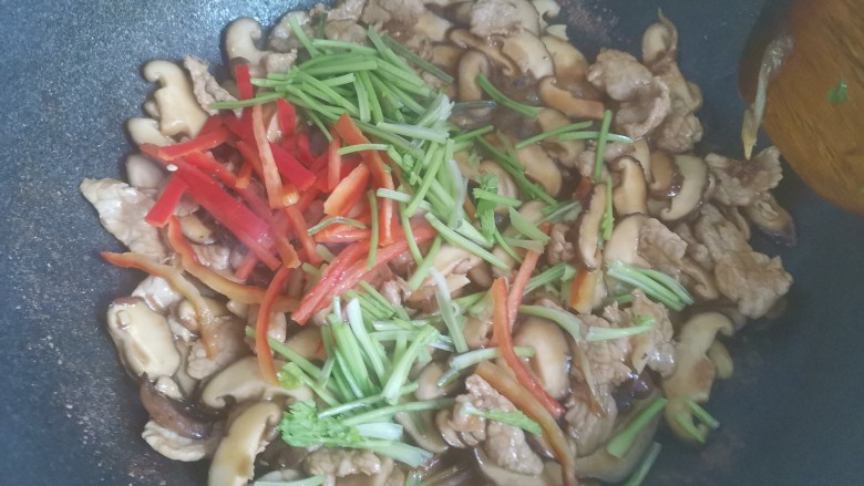 香菇肉片煲,加入红椒丝和香菜段翻炒均匀