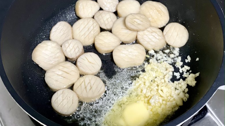 蒜香黄油杏鲍菇,鲜美弹嫩,比肉还好吃!,把杏鲍菇推到一边,下入黄油和蒜末煎香,然后和杏鲍菇混合到一起。