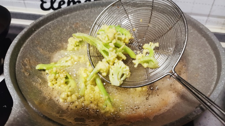 椒盐花菜,油锅里放入花菜,炸至金黄熟透