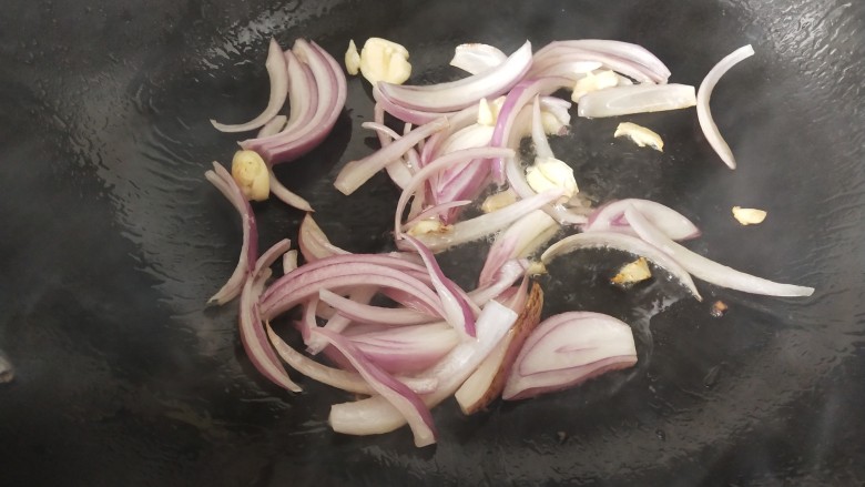 椒盐花菜,锅里热油后,放入洋葱和蒜瓣炒香