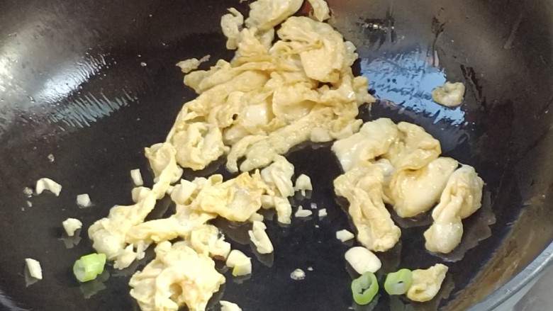 鸡蛋炒粉,鸡呈金黄色时放入蒜与葱