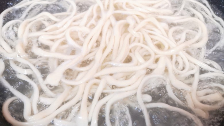大盘鸡拌面,锅里放水烧开,将拉好的面条直接下入锅里,面条比较硬,多煮一会儿。