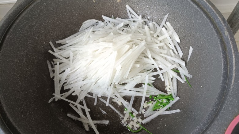 白萝卜炒鸡蛋,葱蒜炒香后,倒入白萝卜翻炒;