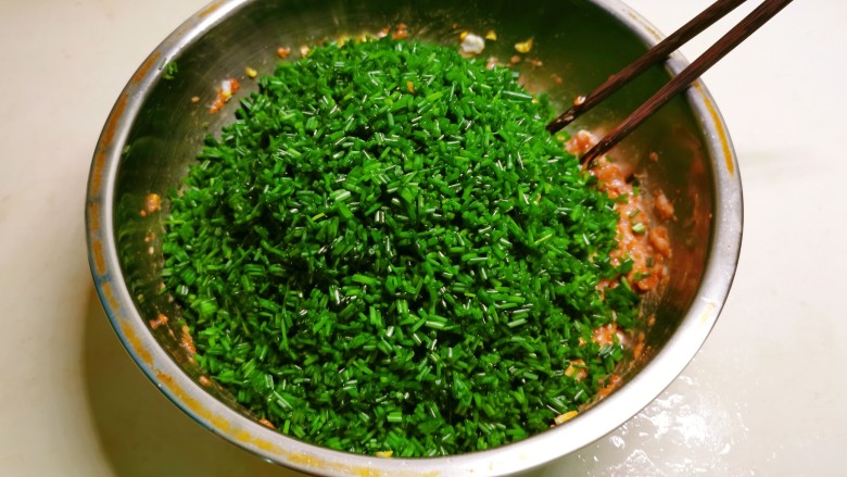 蛤蜊水饺,沙葱切碎放入馅料盆里,淋入<a style='color:red;display:inline-block;' href='/shicai/ 3738'>芝麻油</a>。