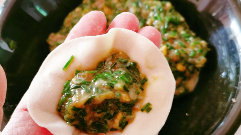 蛤蜊水饺,面团移至面板,分成小剂子,取一份擀成圆片,放入适量馅料。