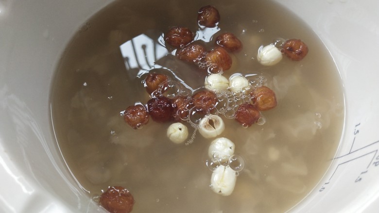 南瓜银耳莲子羹,炖锅里放入桂圆肉和莲子,烧10分钟左右