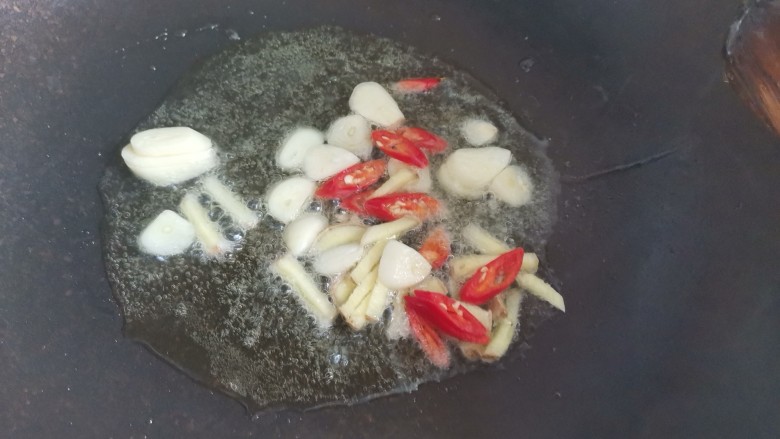 芹菜炒墨鱼,锅烧油下,大蒜,姜片,小米椒爆香
