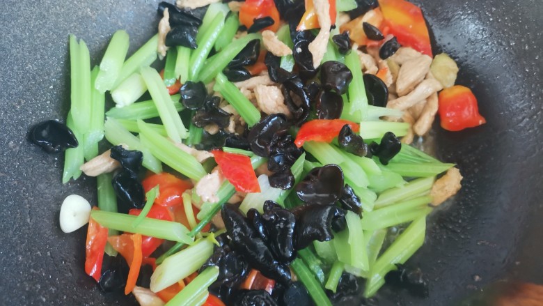 芹菜木耳炒肉丝,倒入木耳,芹菜翻炒均匀