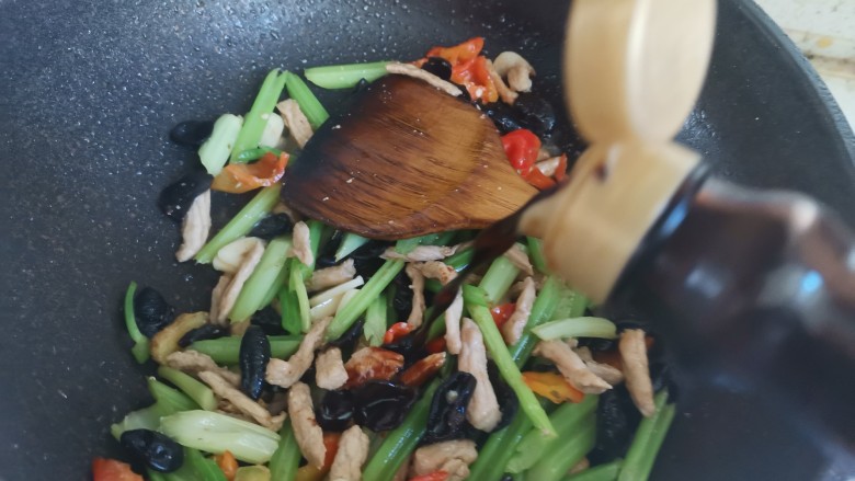 芹菜木耳炒肉丝,加入一勺生抽,翻炒均匀