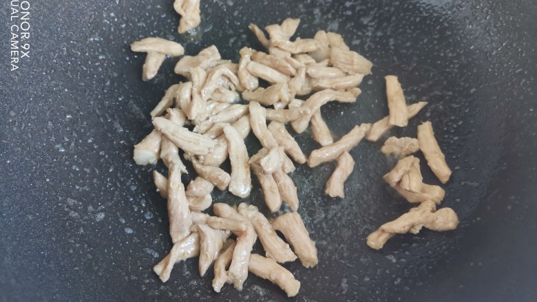 芹菜木耳炒肉丝,锅烧油倒入肉丝,翻炒至变色