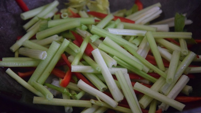 芹菜炒墨鱼,加入红椒丝和芹菜,中火翻炒至变软
