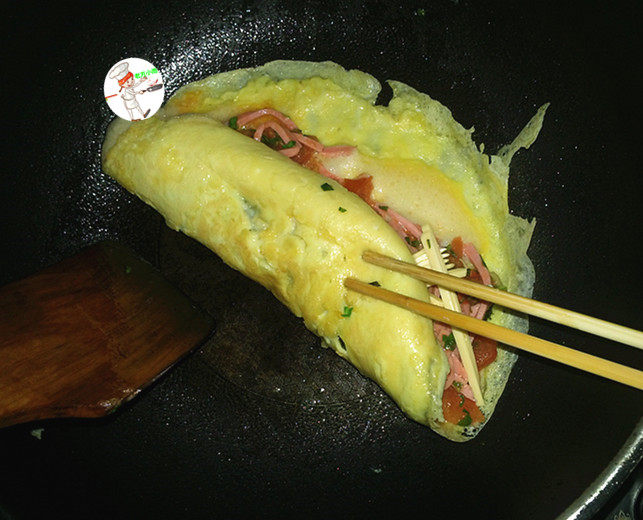 奶酪酥饼,借助锅铲和筷子,轻轻地将蛋饼卷起来