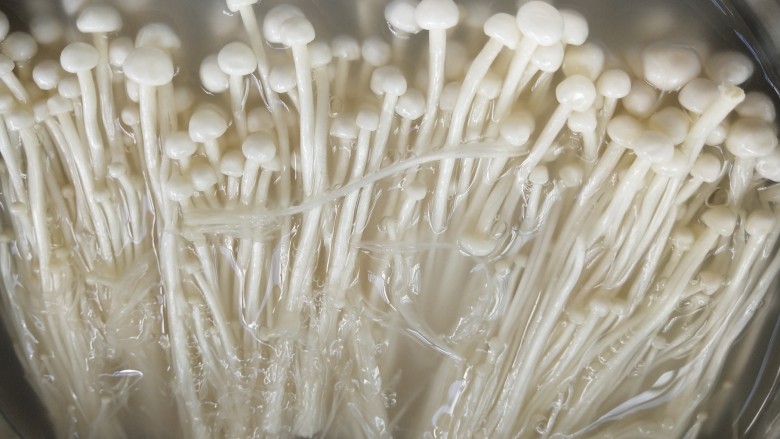 金针菇炒娃娃菜,把金针菇尾部去掉,泡洗米水中大约10分钟左右
