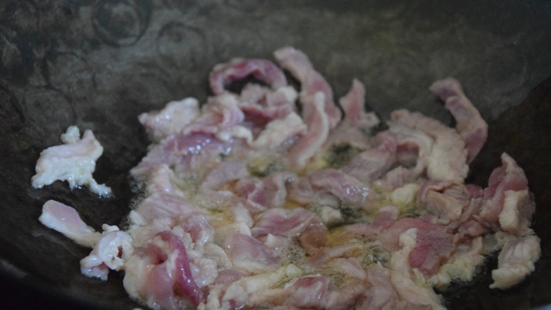 芹菜木耳炒肉丝,热锅凉油,倒入肉丝炒至断色