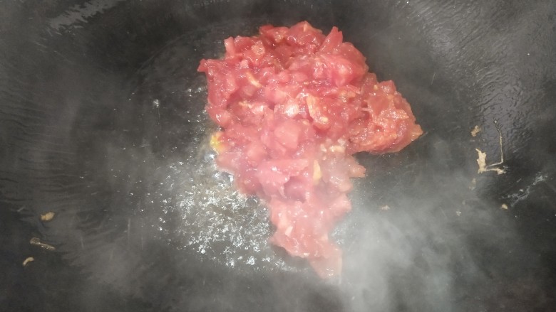 番茄鸡蛋炒年糕,锅里再放油,这次要多一点,放入番茄,加点白糖炒出汁