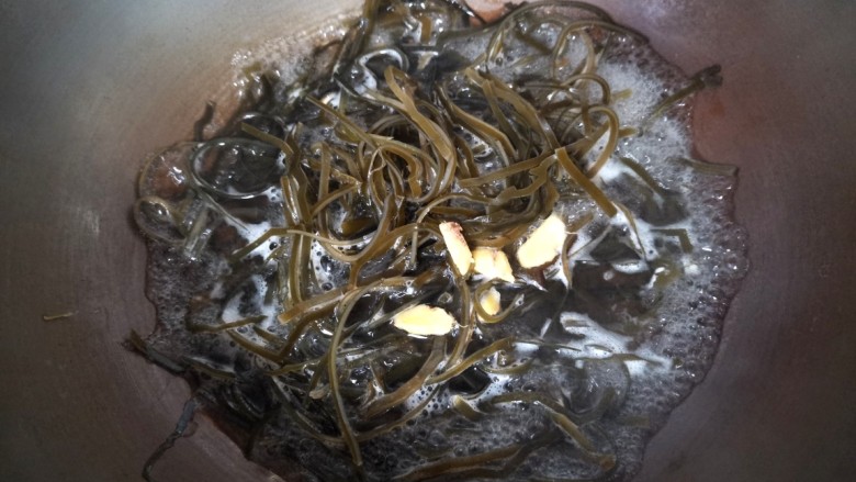 凉拌芝麻海带,锅里水开加入料酒,姜片,放入海带丝烧1-2分钟