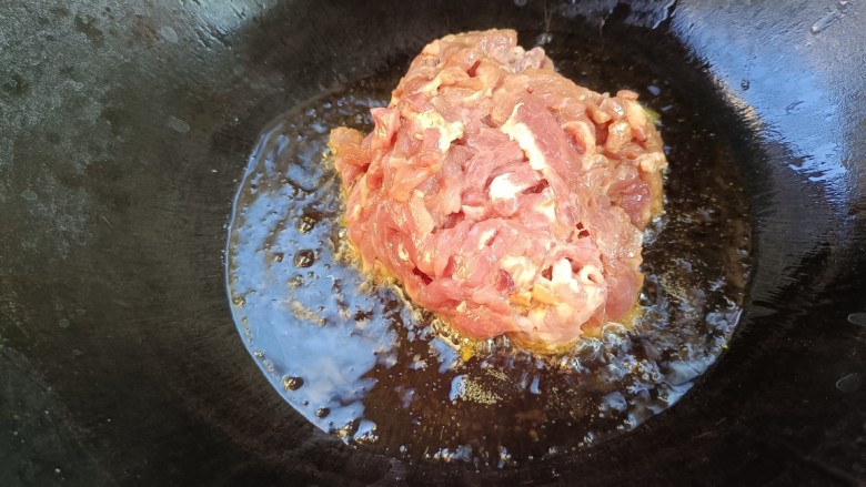 青葱炒肉丝,起锅烧油,放入浆好的肉丝,炒变色,捞出