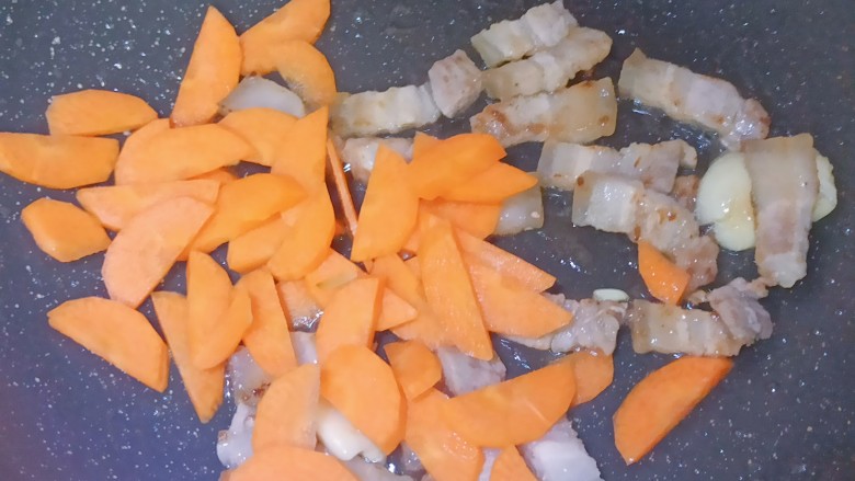 五花肉炒黄瓜,加入五花肉,翻炒至变色,再逼出里面的一些油后加入胡萝卜翻炒