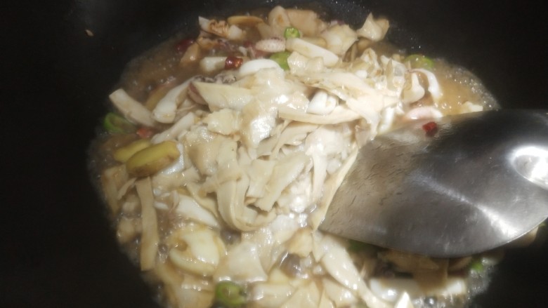 笋干炒墨鱼,倒入笋干翻炒,加点开水炒,出锅前倒一点生抽