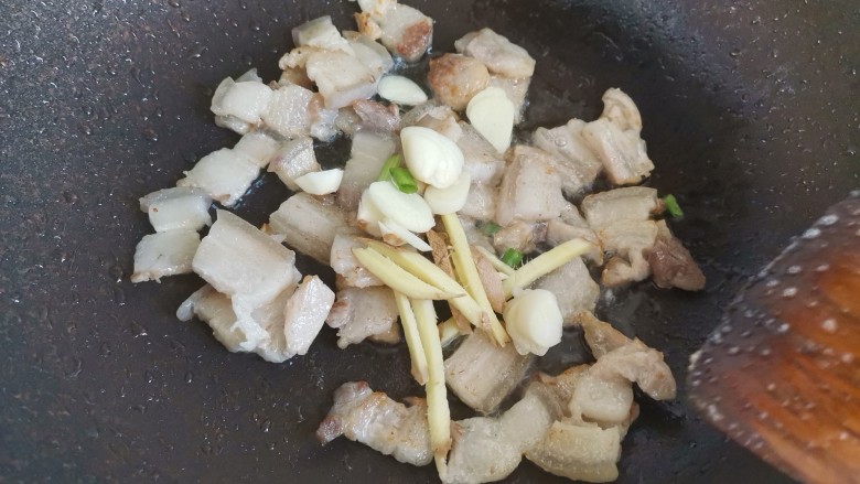 五花肉炒黄瓜,炒至五花肉表面微焦出肥油,下入葱姜蒜炒香
