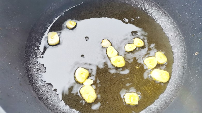 土豆炒腊肠,另起锅热油,倒入蒜片爆香,